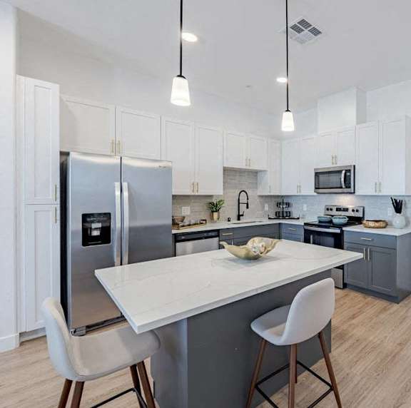 A modern kitchen with a white table and chairs.
