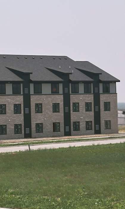 A large grey building with black trim and multiple windows.