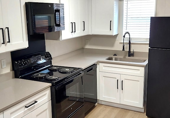 a small kitchen with black appliances and white cabinets