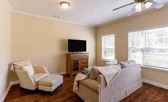 A living room with a couch, chair, and television.