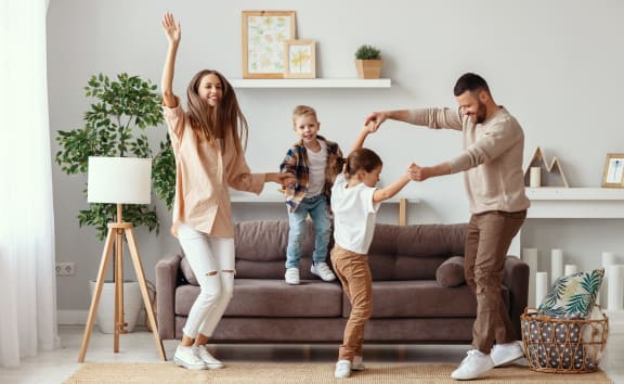 the happy family is dancing in the living room