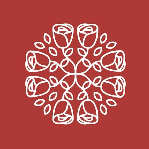 A white line drawing of a circular pattern with leaves and flowers on a red background.