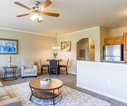 A living room with a white couch and a ceiling fan.