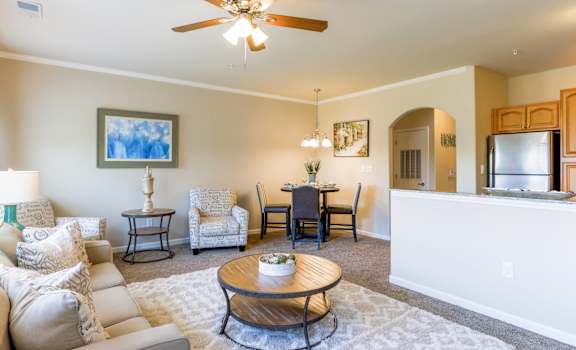 A living room with a white couch and a ceiling fan.