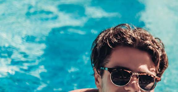 three people in a swimming pool wearing sunglasses