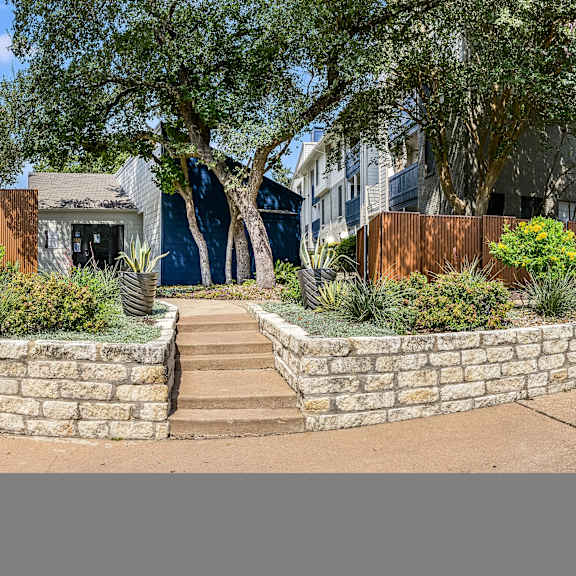 a retaining wall with stairs in front of a house at Peaks at Northwest Hills Apartments, Austin