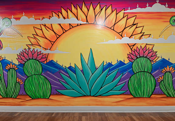 person painted this mural of cacti in the desert