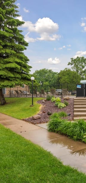 A park with a paved walkway, a grassy area, and a tree. at Silver Lake, New Brighton, 55112