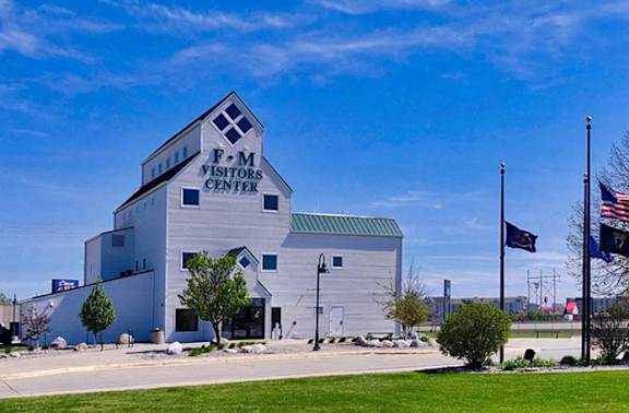 a white building with an flag in front of it and a blue sky