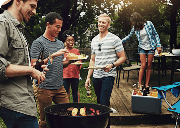 A group of people enjoying a barbecue in a backyard.