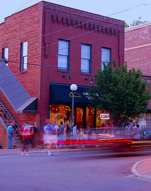 A busy street corner with a stop sign and a sign for Heritage North Charlotte.