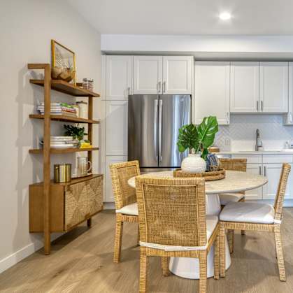 A kitchen with a table and chairs in the middle of it.