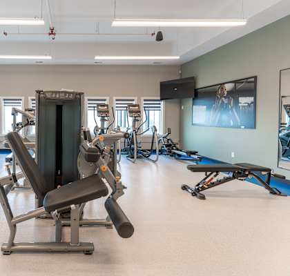 A gym with a variety of equipment including a leg press machine.