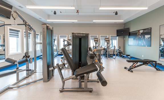 A gym with a variety of equipment including a leg press machine.at Vista Apartments at Edgemont, Edmonton Alberta