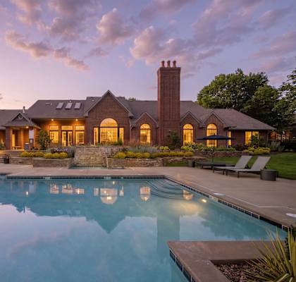 A large house with a pool in front of it.