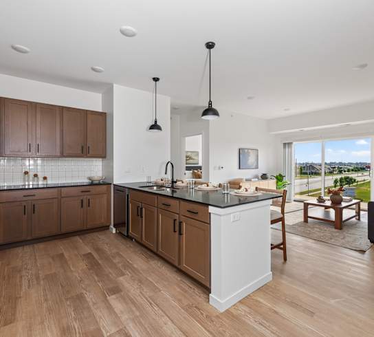 A modern kitchen with wooden floors and a large island.