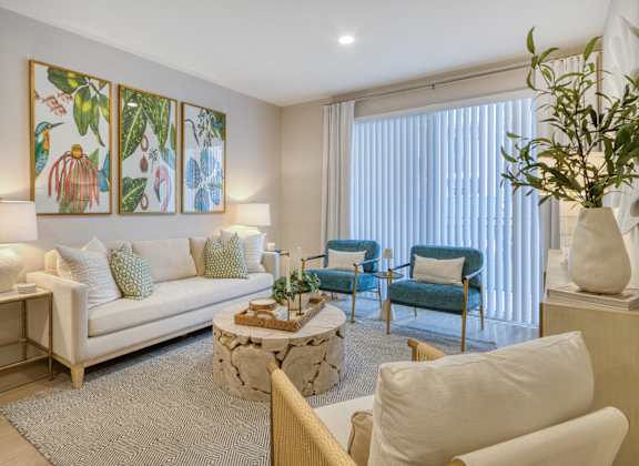 A living room with a white couch, a coffee table, and a painting on the wall.