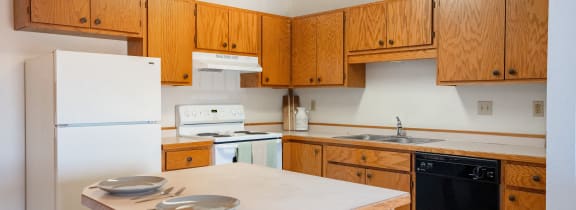 a kitchen with white appliances and wooden cabinets