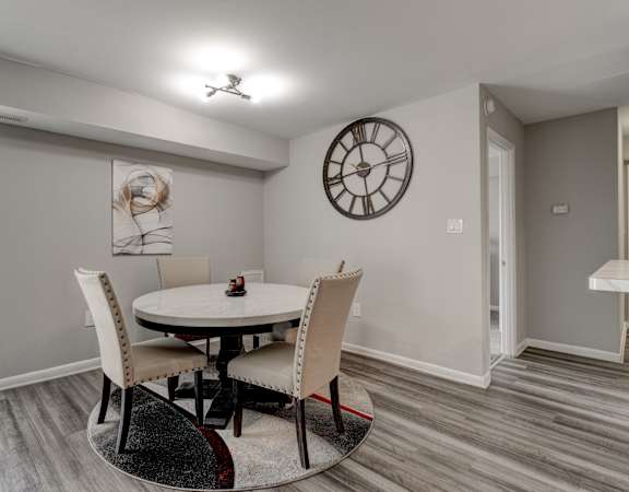 A dining room with a round table and chairs.