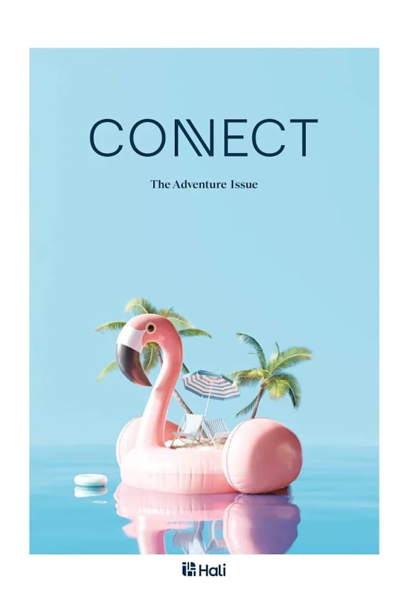 A pink flamingo floats on a pool with a beach chair and palm trees.
