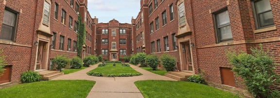 a view of a courtyard in the middle of some apartments
