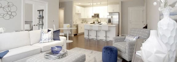 a white living room and kitchen with blue and white furniture
