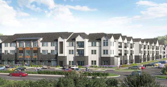A row of modern townhouses with cars parked in front.