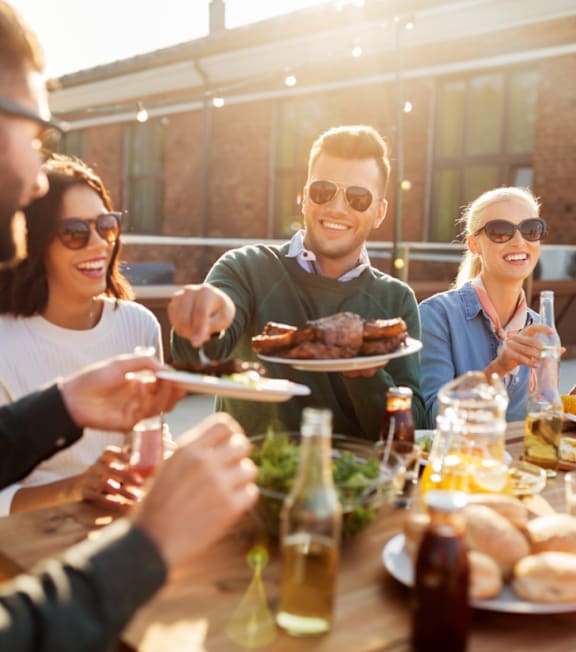 Group of People Smiling and Eating Food