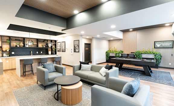 A modern living room with a grey couch and a black coffee table.