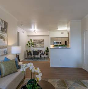 A living room with a couch, a table, and a painting on the wall.