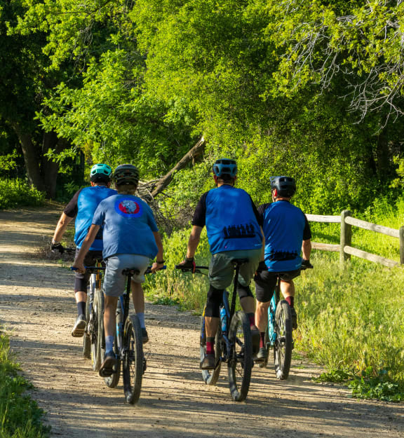 a group of people riding bikes down a dirt trail