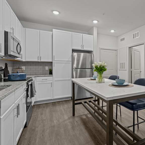 a kitchen and living room with a table and chairs
