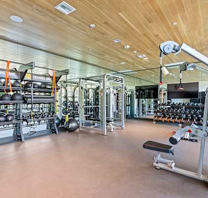 Gym with weights and cardio equipment on the floor and a wooden ceiling at Array La Mesa, La Mesa