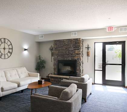 A living room with a couch, chairs, and a fireplace.