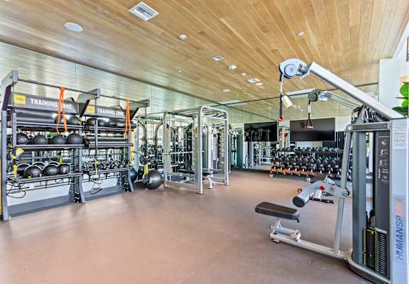 Gym with weights and cardio equipment on the floor and a wooden ceiling at Array La Mesa, La Mesa