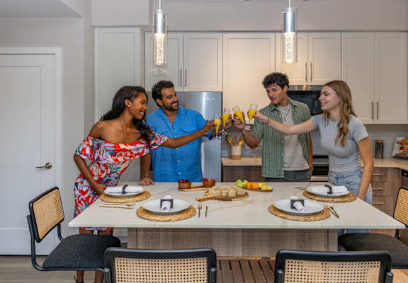 Four people are standing around a table with food and drinks at Portofino Vineyards, Fort Myers, FL, 33967