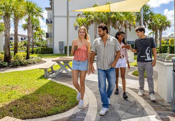 Group of people walking in a park-like setting at Portofino Vineyards, Fort Myers, Florida