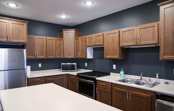 A kitchen with wooden cabinets and a white countertop.