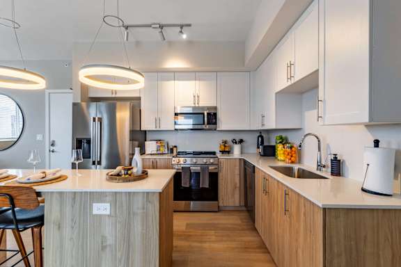 A modern kitchen with wooden cabinets and a white island.at Icon One, Daytona Beach