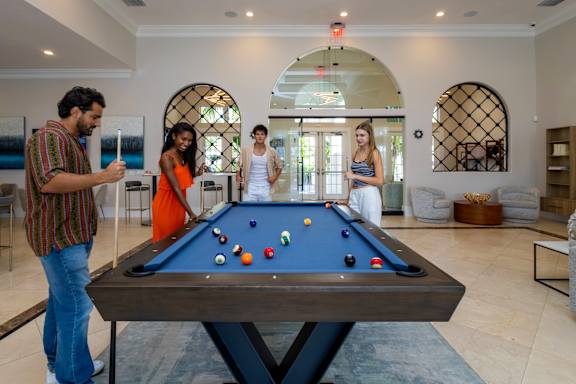 Four people are playing pool at The Falls of Portofino , Naples, Florida