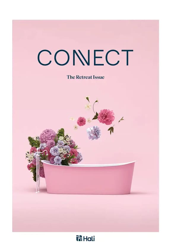A pink bathtub with flowers floating in it.