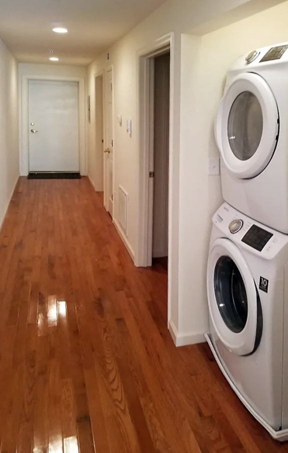 a laundry room with a washer and dryer on a wooden floor