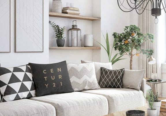 a living room with a couch and pillows and a window