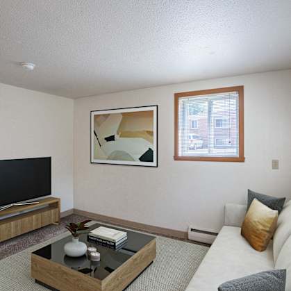 a living room with a couch and a coffee table and a television. Fargo, ND Forest Avenue Apartments