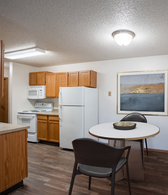 a kitchen and dining area with a table and chairs and a refrigerator