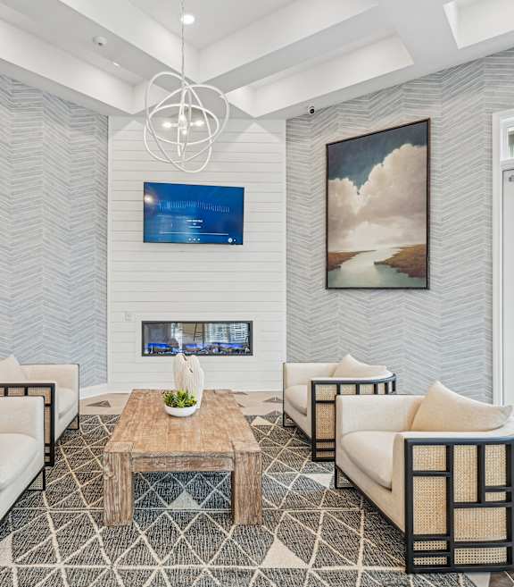 A modern living room with a fireplace and a painting on the wall.at The Parker Leland, Leland North Carolina