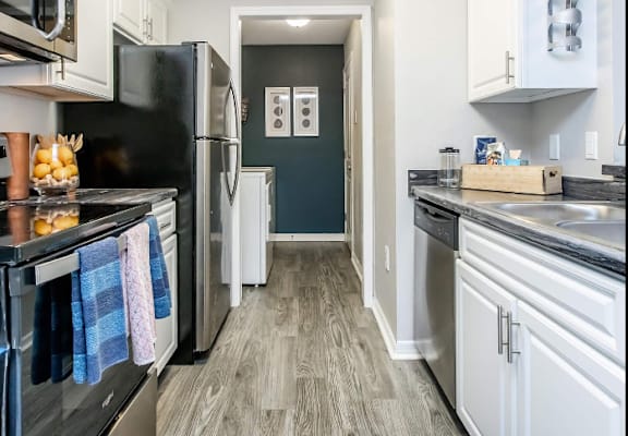 A kitchen with black appliances and white cabinets.