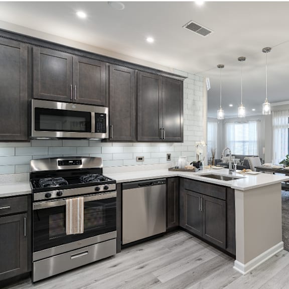 A modern kitchen with dark wood cabinets and stainless steel appliances.