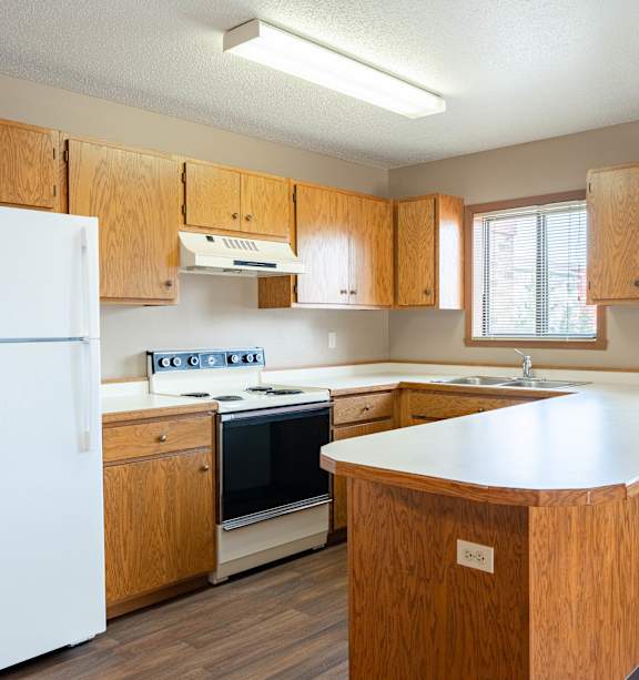 A kitchen with wooden cabinets and a white refrigerator.