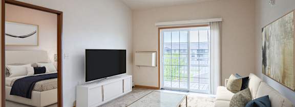 A living room with a white couch and a black television.